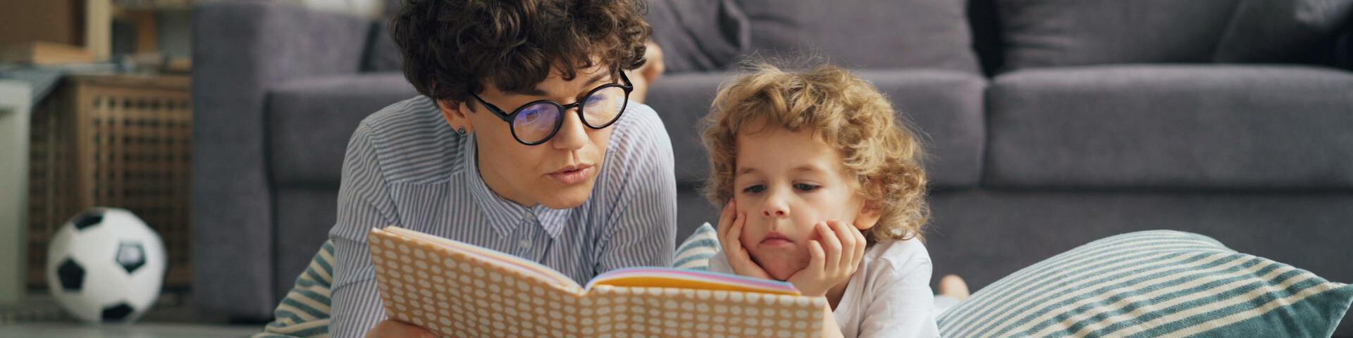 Frau und Kind lesen gemütlich gemeinsam ein Buch