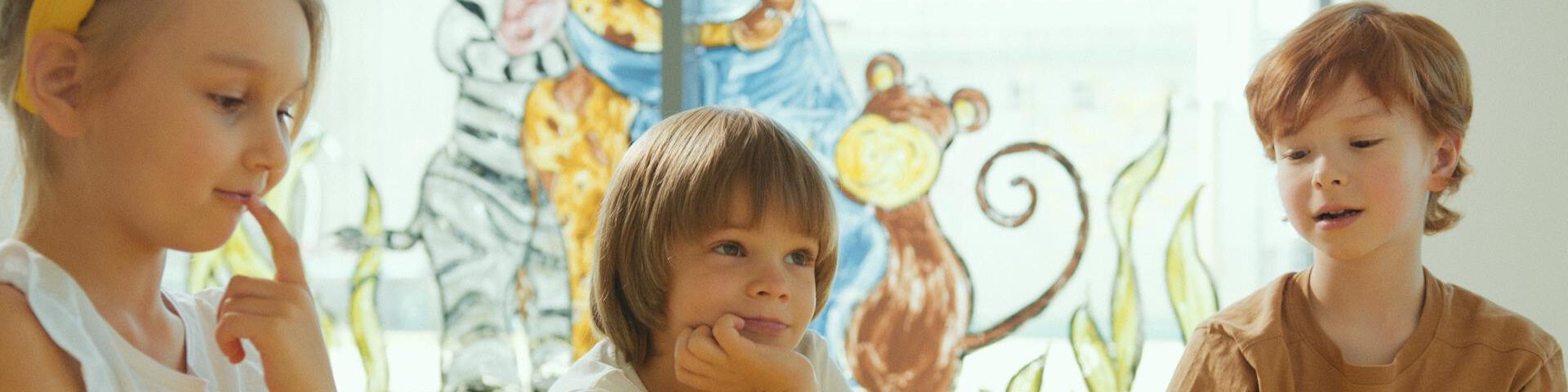 Bilderbuchkino – Magie der Leinwand. 3 Kinder sitzen vor einer Leinwand